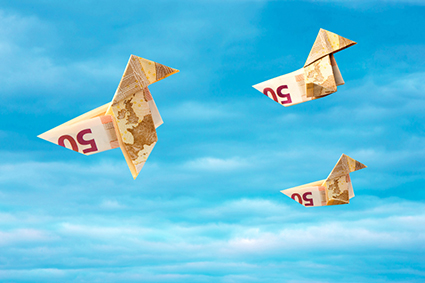 Bank note paper birds flying away on blue sky alternate text for this image