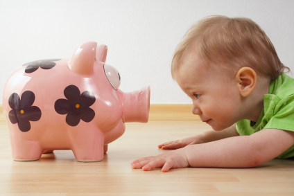 child looks at a piggy bank alternate text for this image