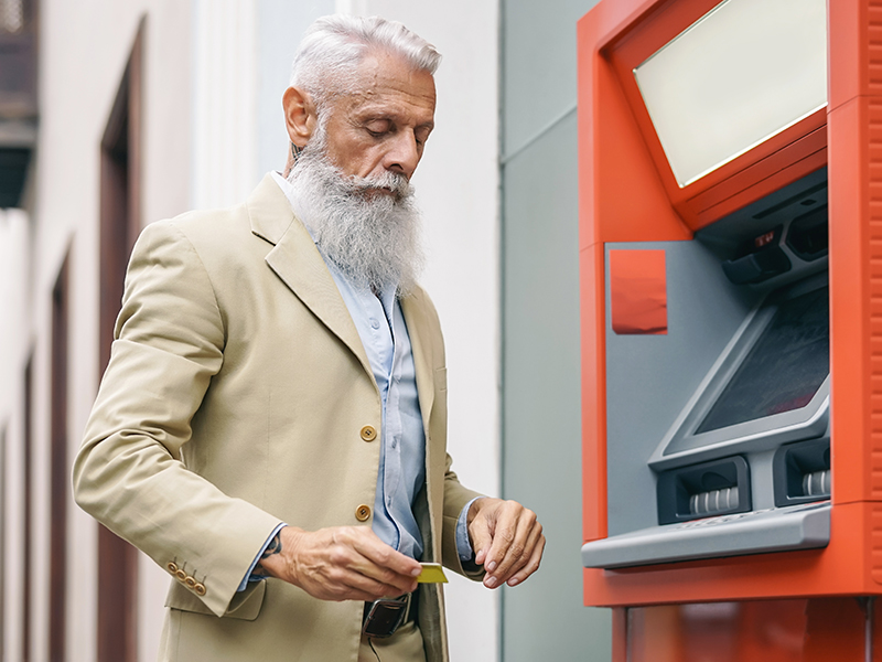 Homme âgé au guichet automatique