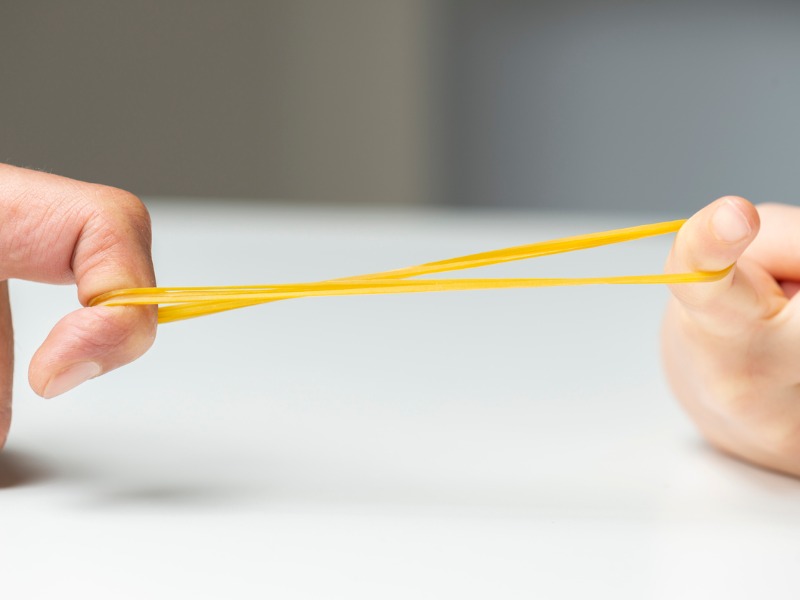 Deux personnes étirant ensemble un élastique.