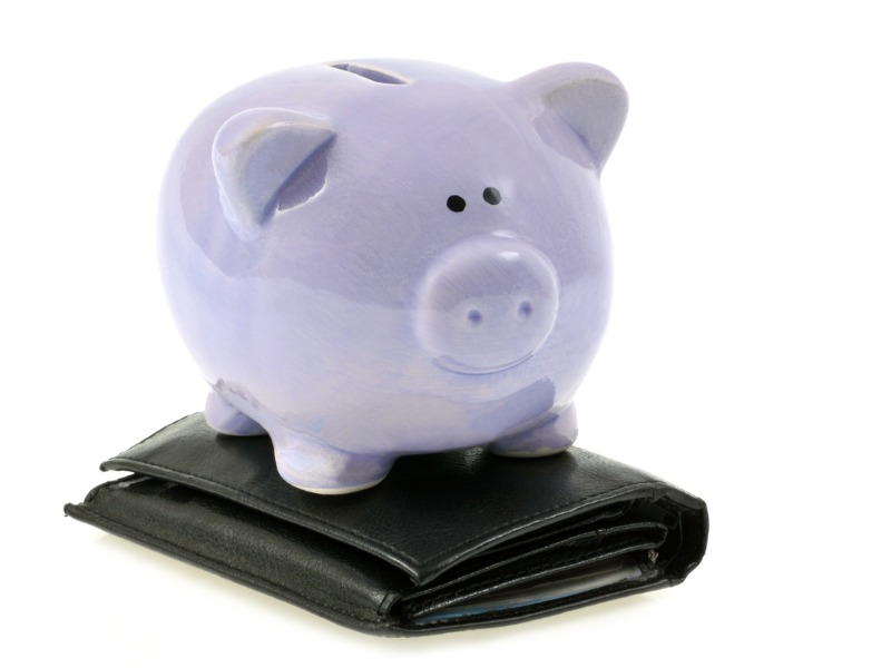 Une tire-lire posée sur un portefeuille.