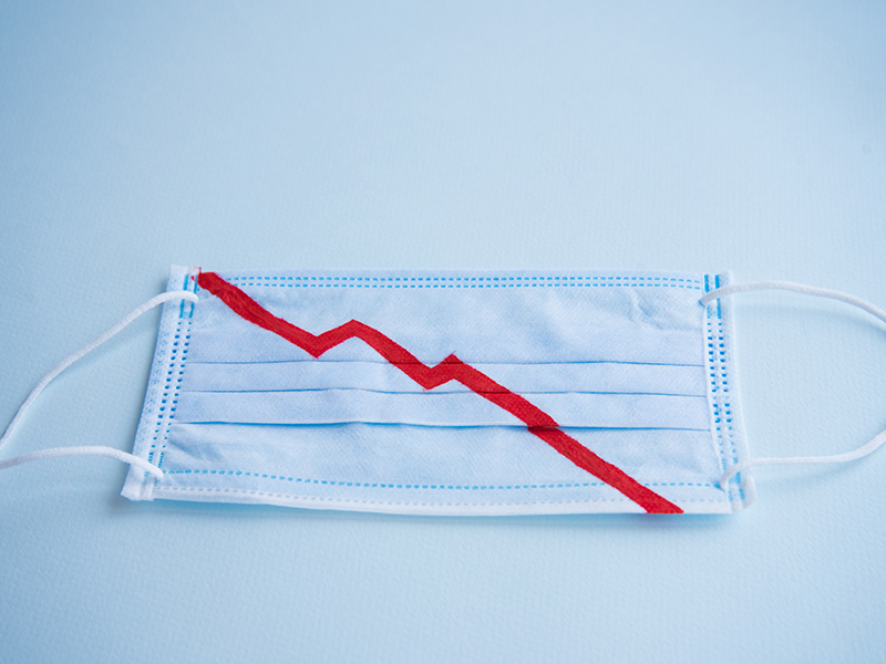 Blue medical mask for protection against virus and other diseases. On the mask, the red color indicates the graph of the fall. Financial collapse. Market decline. Concept. alternate text for this image