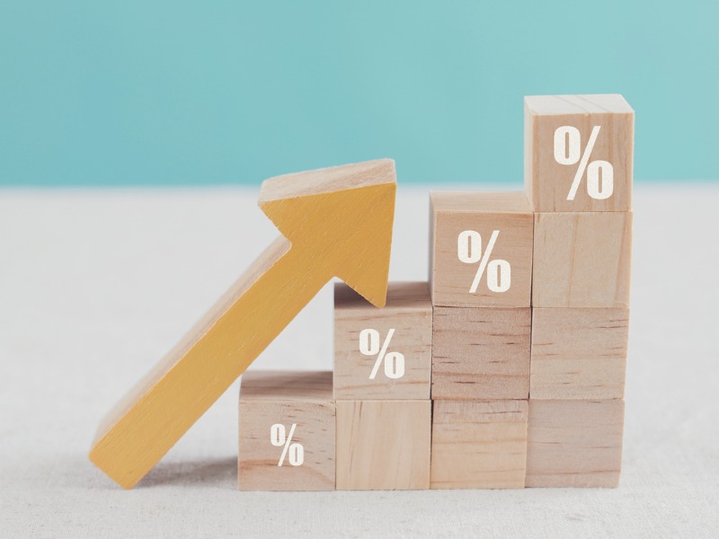 Un escalier fait en blocs, sur lesquels est dessiné le signe de pourcentage. Une flèce en bois est posée dessus indiquant le haut.