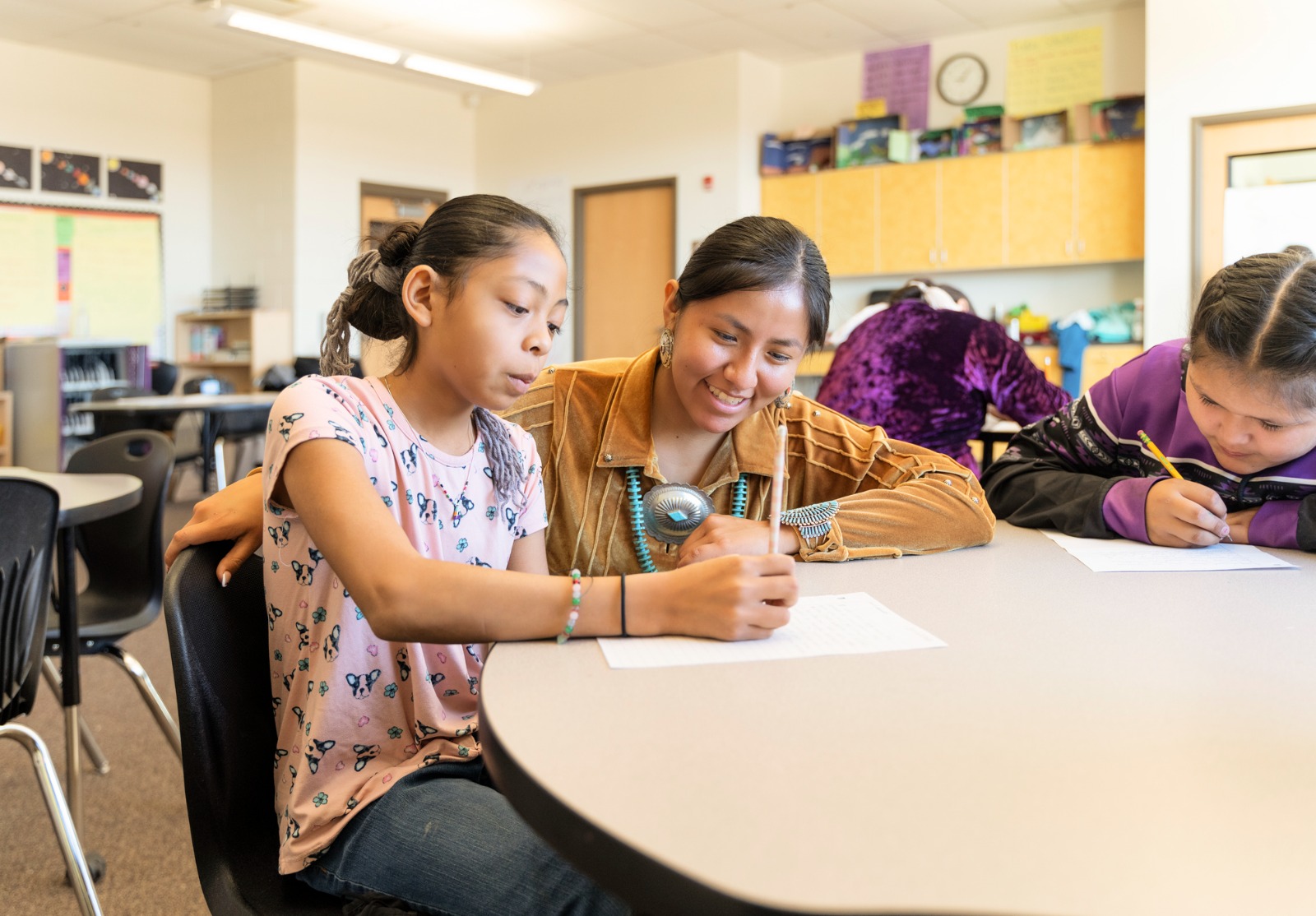 Un enseignant navajo autochtone aide les élèves dans leur travail.