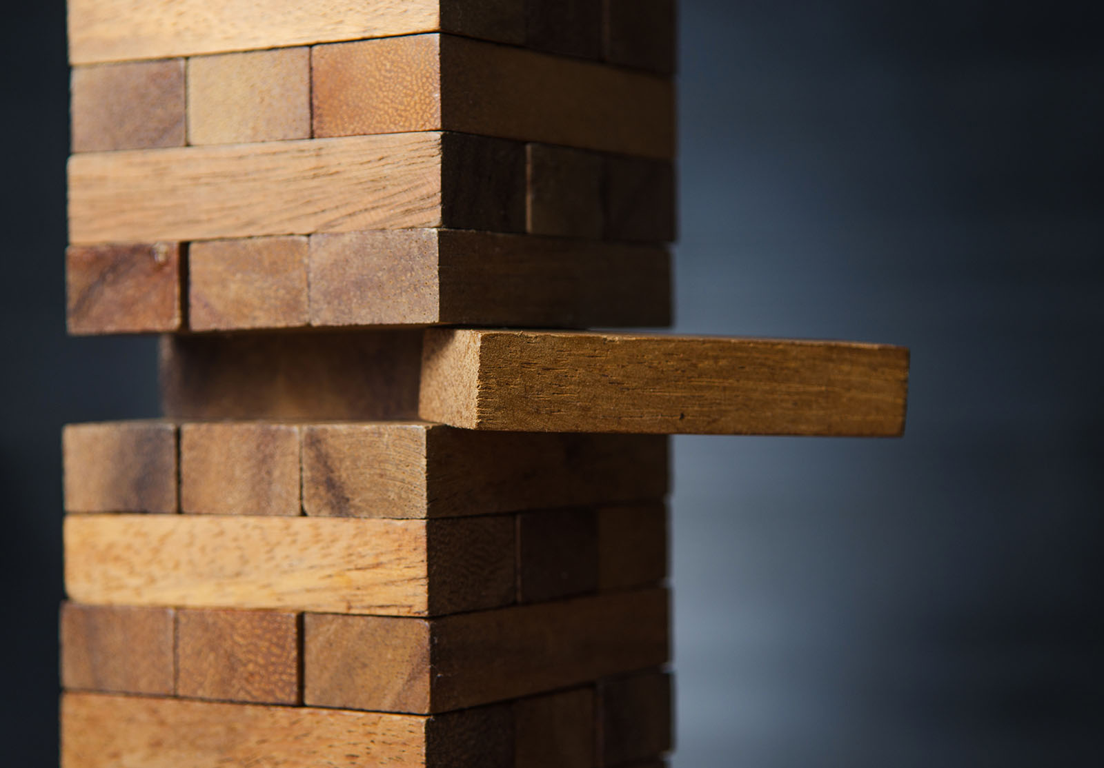 Gros plan d'un bloc sur la tour de blocs de bois, ton foncé