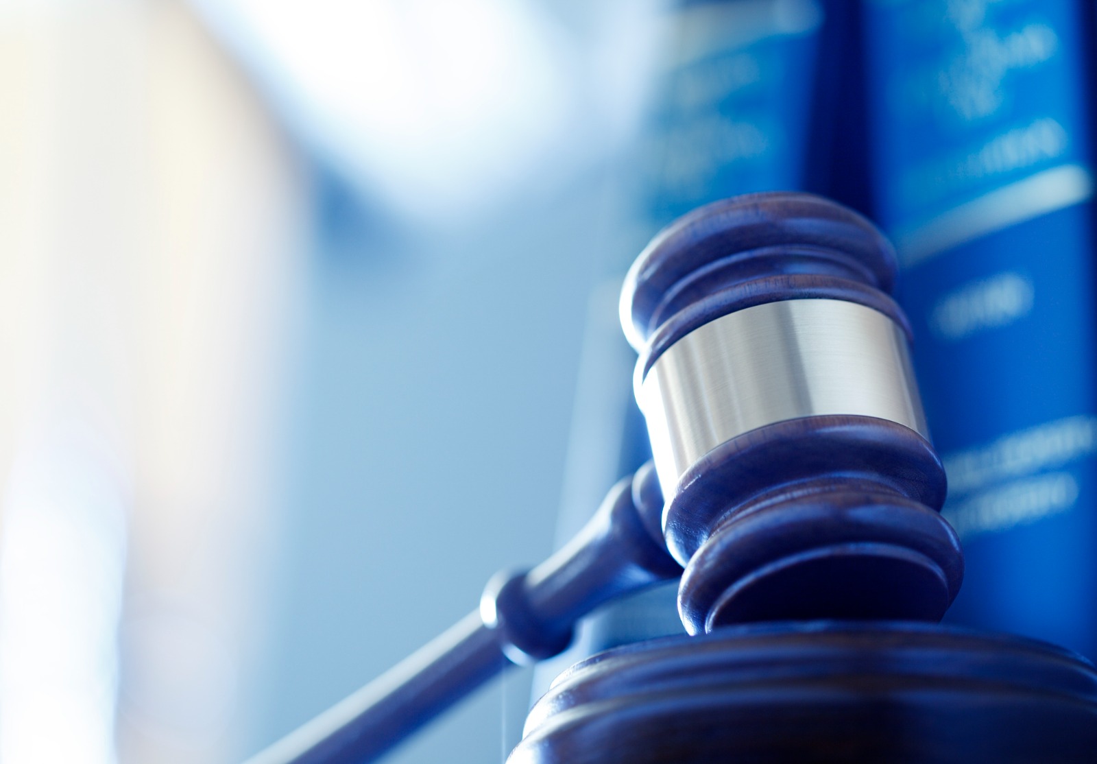 Marteau de juge devant une rangée de livres de droit.