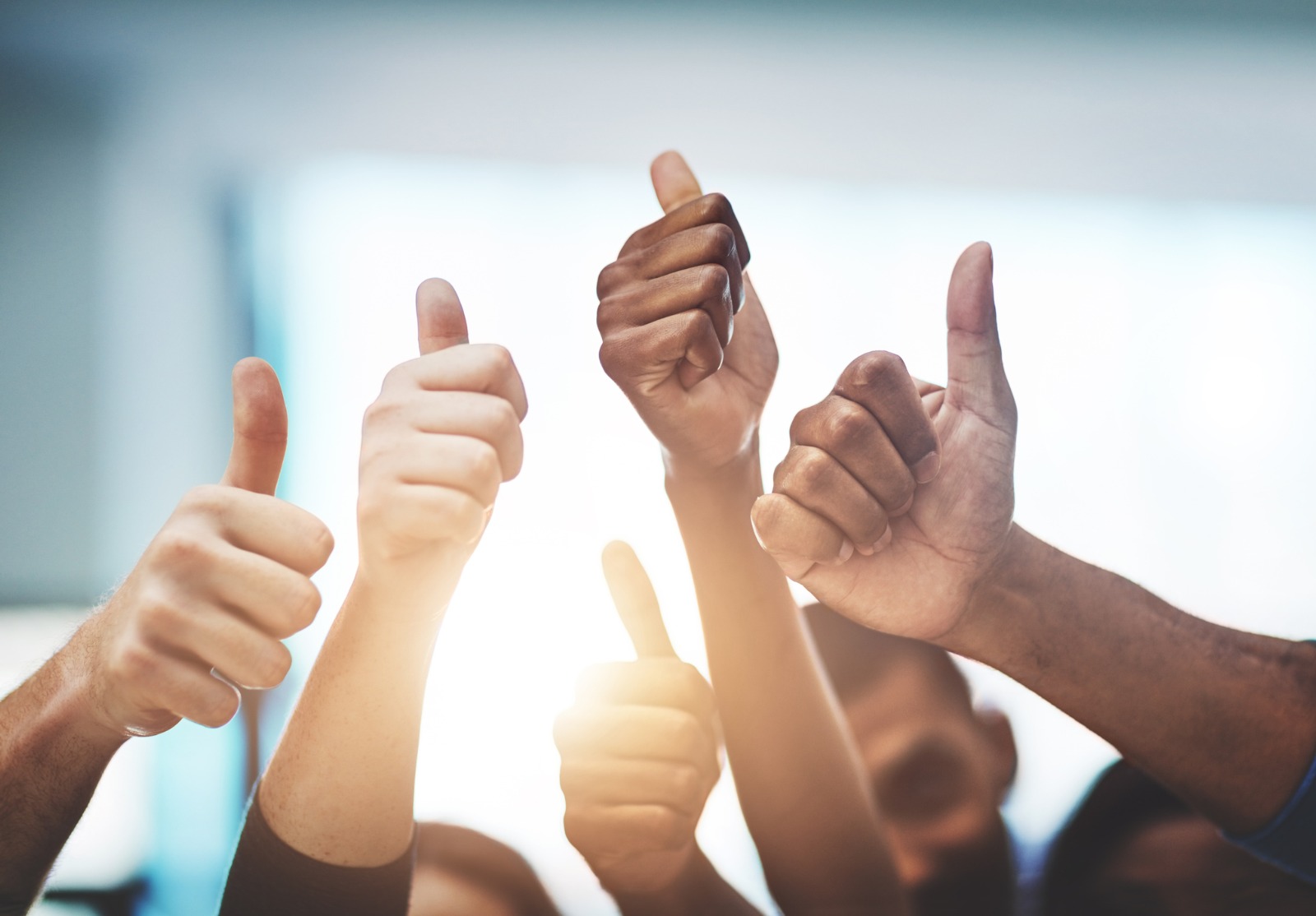 Plusieurs mains levées faisant le signe du pouce.