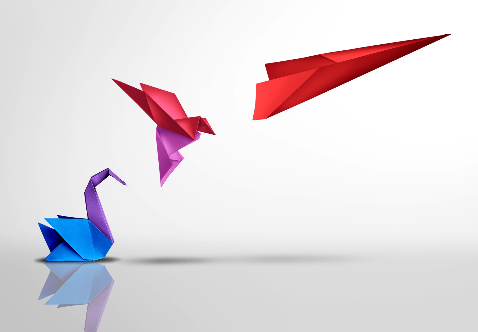 Trois origamis différents. Le premier représente un cygne. Celui-ci se transforme en oiseau puis en avion en papier.