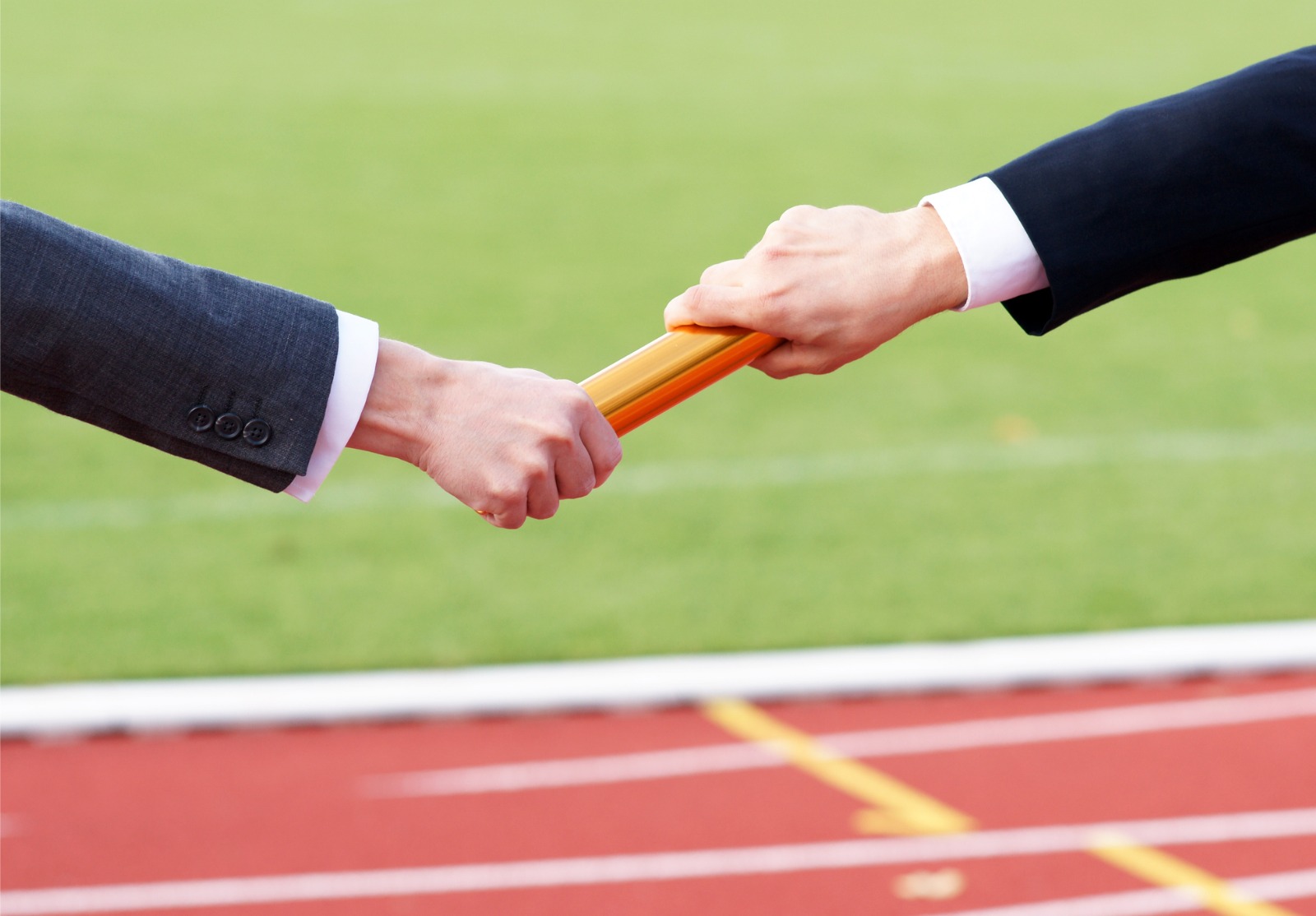 Homme d'affaires passant le bâton d'or dans la course de relais