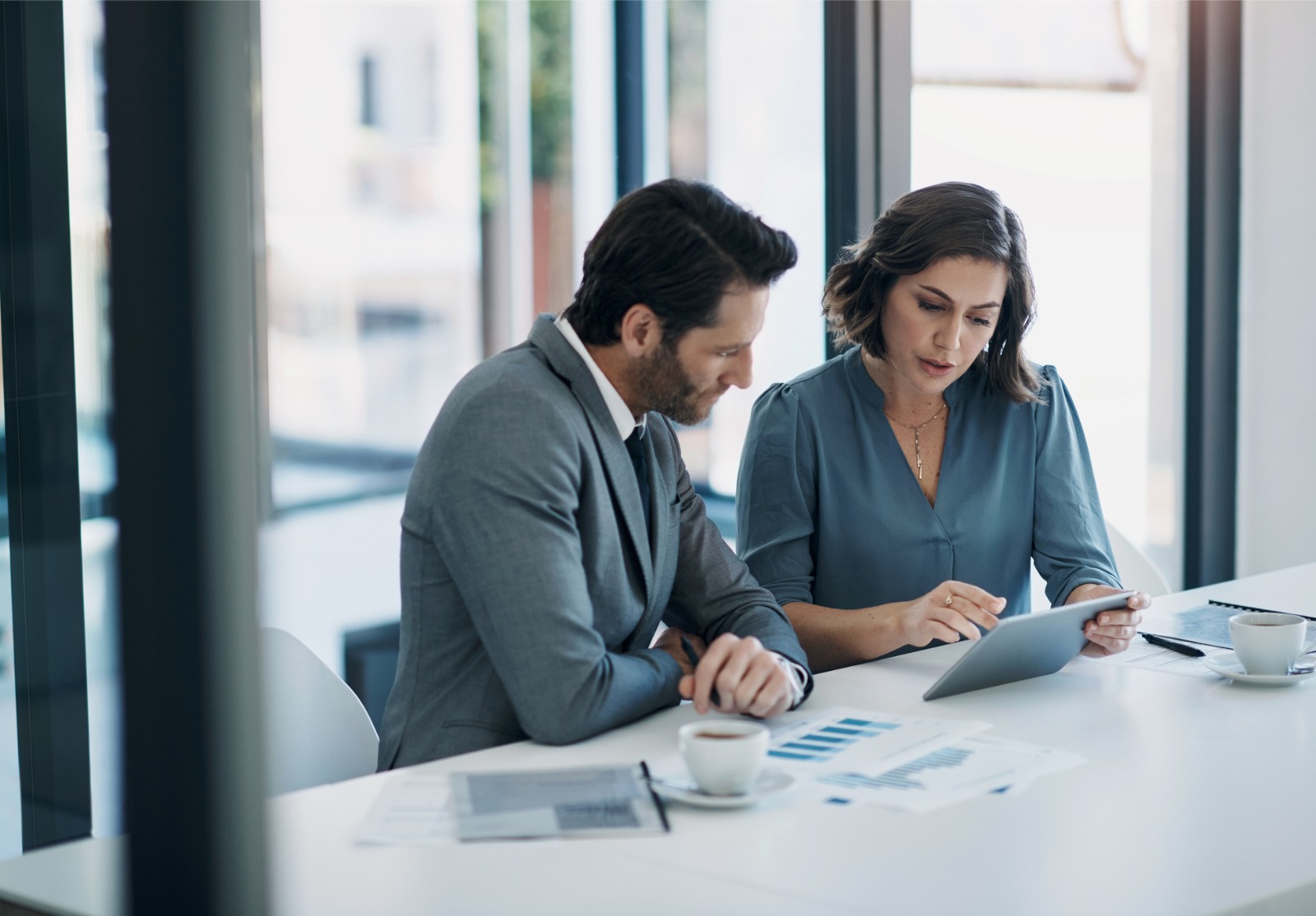 Hommes d’affaires, travail d’équipe et tablette pour les statistiques, le rapport financier et la planification des revenus, des bénéfices ou des ventes au bureau. Conseiller professionnel ou clients avec analyse de données, graphiques et tableaux.