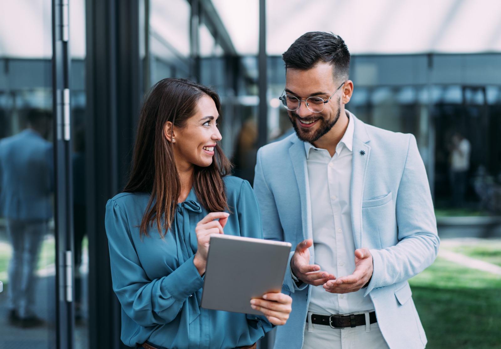 Business people using digital tablet outdoors.