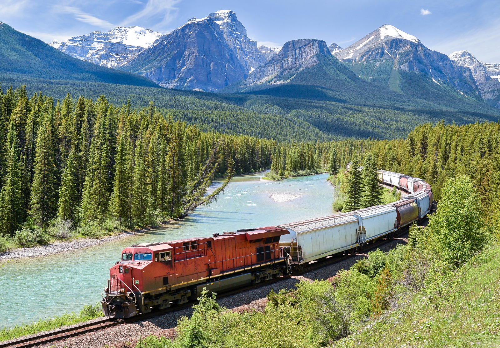 Train de marchandises circulant le long de la rivière Bow dans les Rocheuses canadiennes, Alberta, Canada.