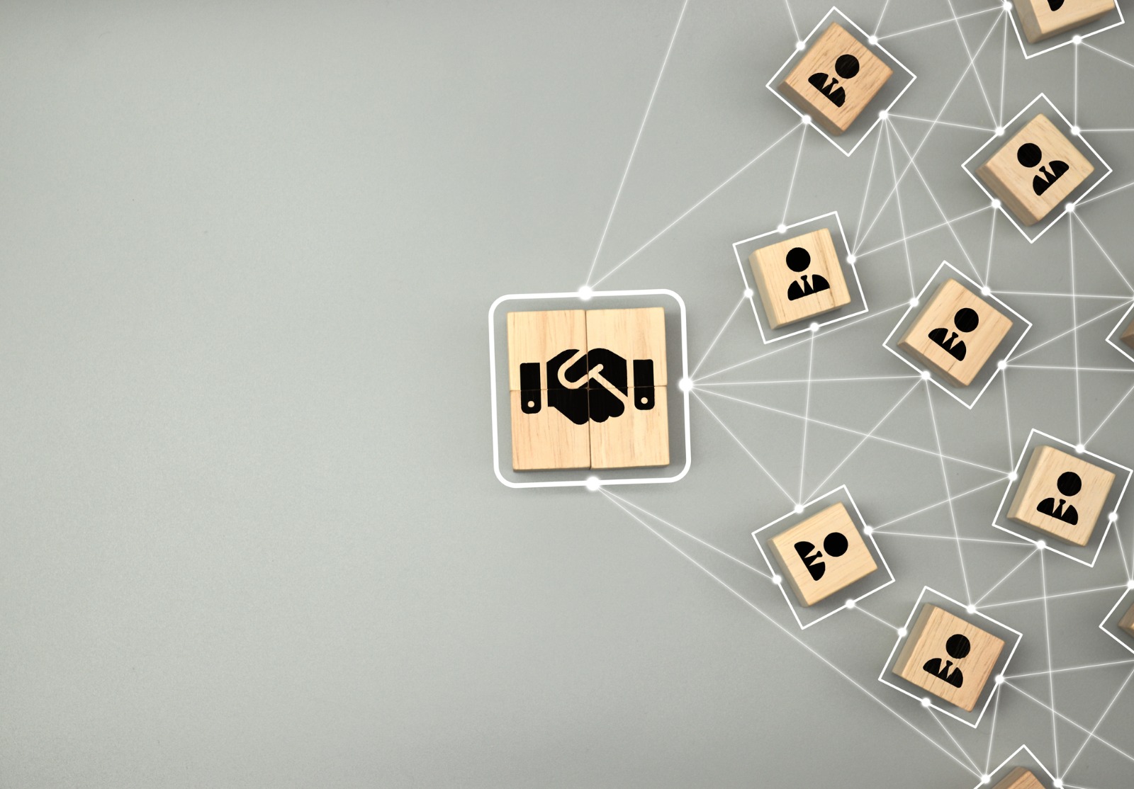 Icône de poignée de main sur un bloc de cube en bois qui se connecte à l’icône humaine pour le concept d’accord et d’accord d’affaires.