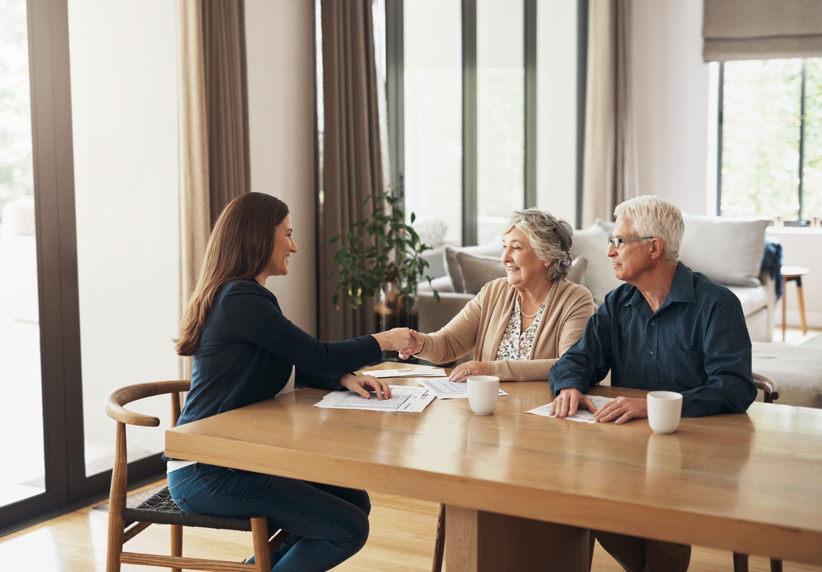 Poignée de main, courtier ou vieux couple heureux consultant en réunion pour des conseils de pension de retraite ou de facture fiscale. Conseiller financier, homme âgé ou femme âgée serrant la main pour un accord d’investissement ou un plan d’épargne.
