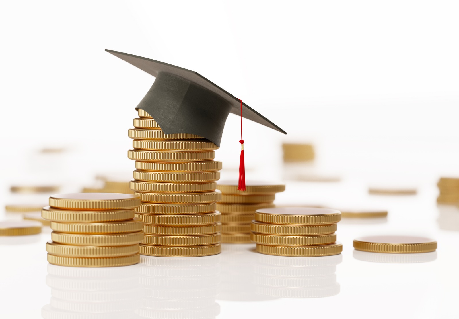 Pile de pièces et d’un mortier noir sur fond blanc - l’éducation et la notion d’épargne.