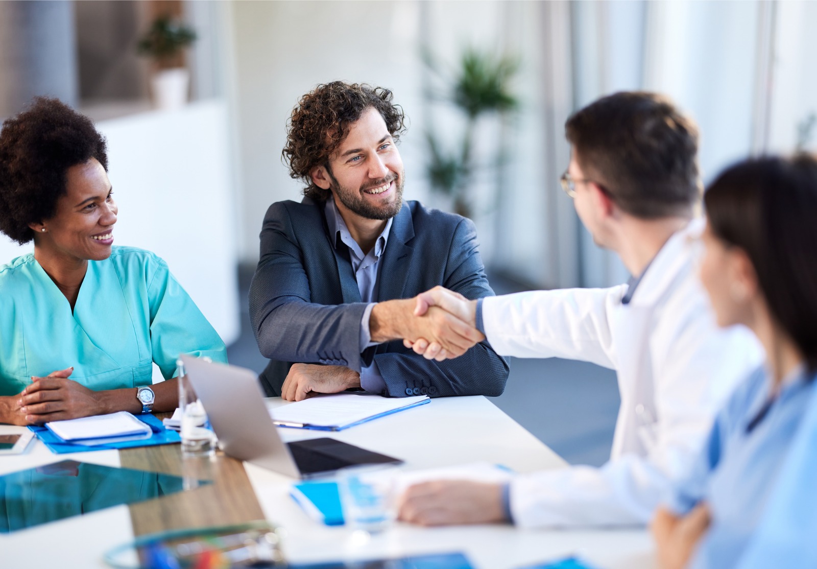 Deux hommes se serrant la main à une table de réunion.