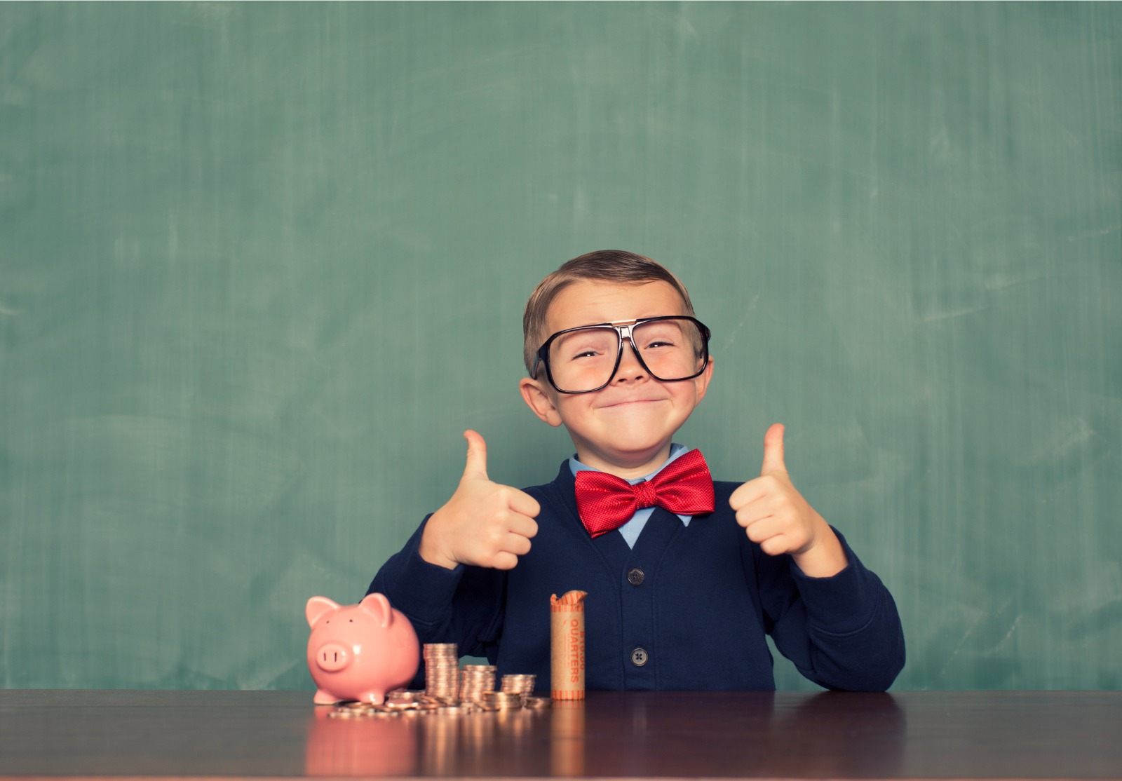 Jeune garçon de Nerd d'économiser de l'argent dans sa Tirelire en forme de cochon.