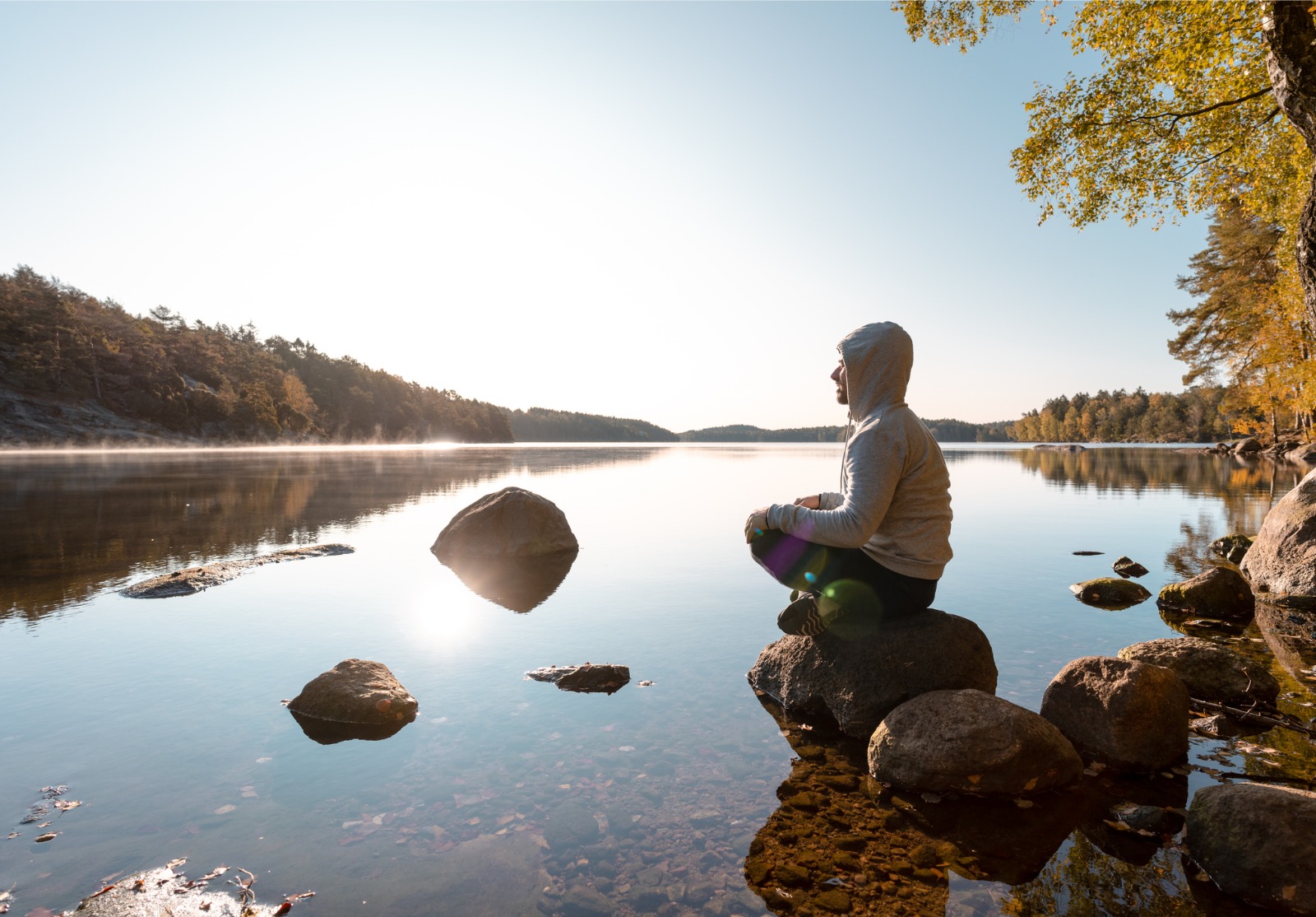 Homme méditant par le lac après un exercice extérieur.
