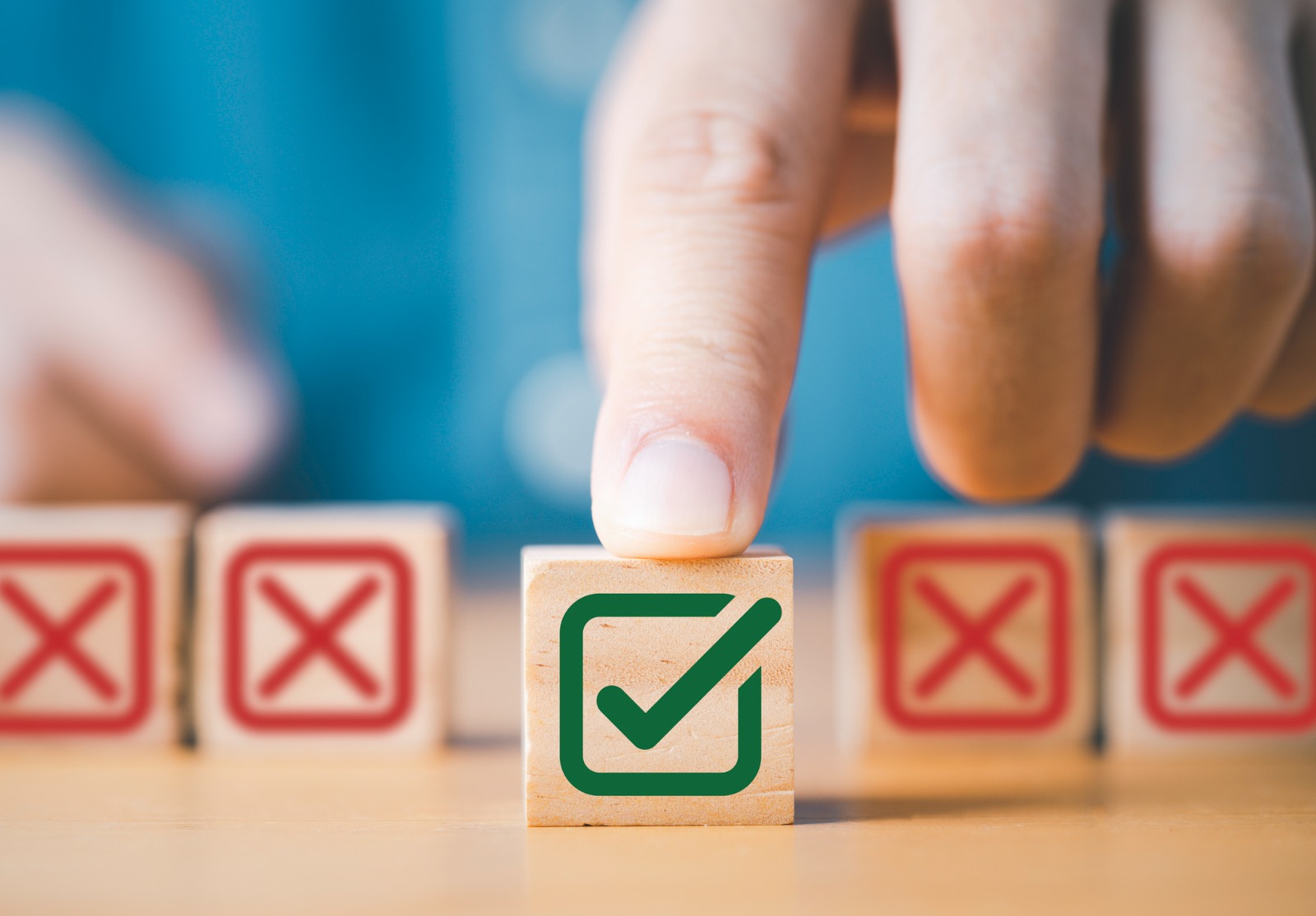 Appuyez à la main sur le symbole vert correct du signe devant le signe de la Croix-Rouge sur un cube de blocs de bois pour la proposition commerciale et le concept d’approbation de document.