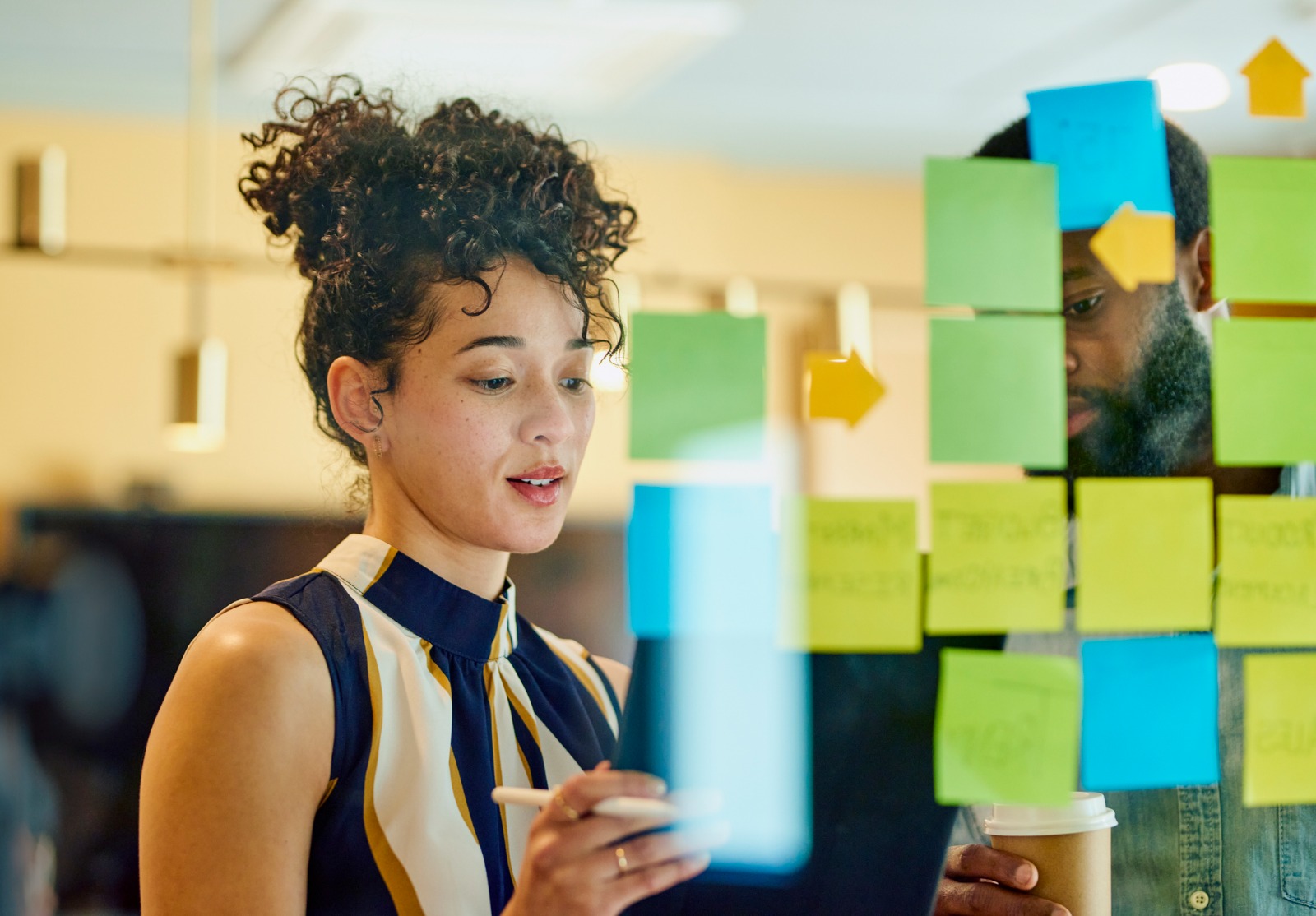 Deux professionnels discutent d’idées dans un bureau.