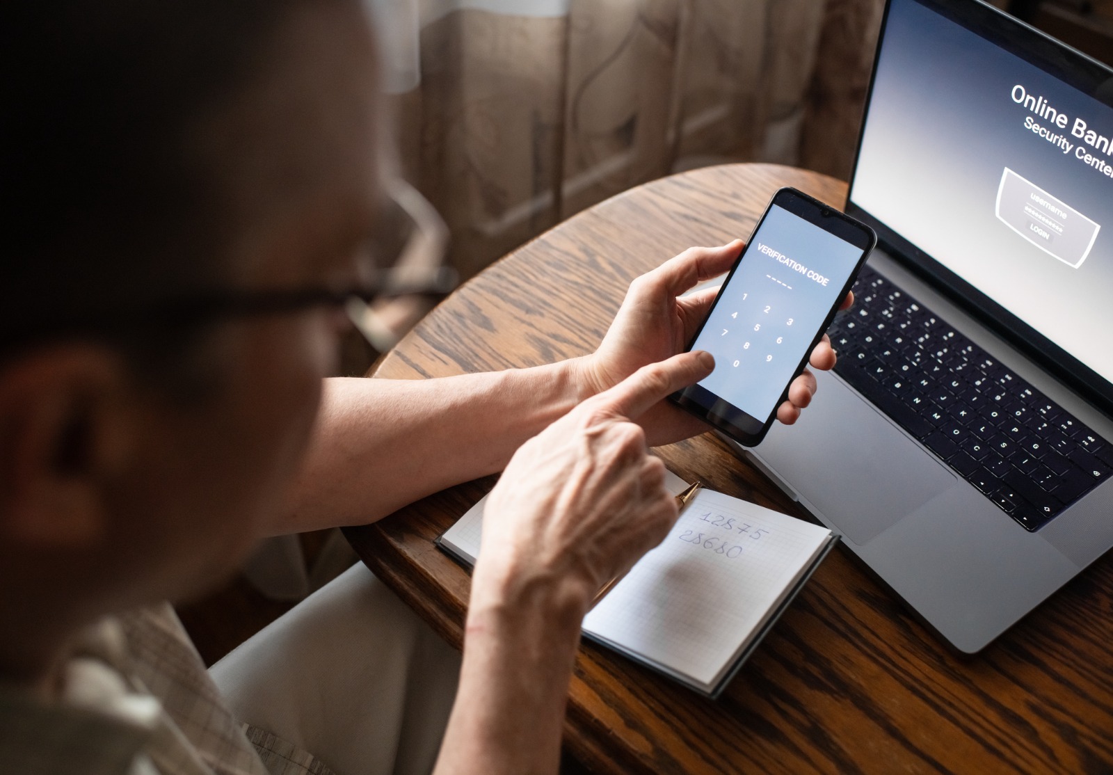 Homme âgé sérieux à la maison entrant le code de vérification dans le smartphone, concept de prévention de la fraude.