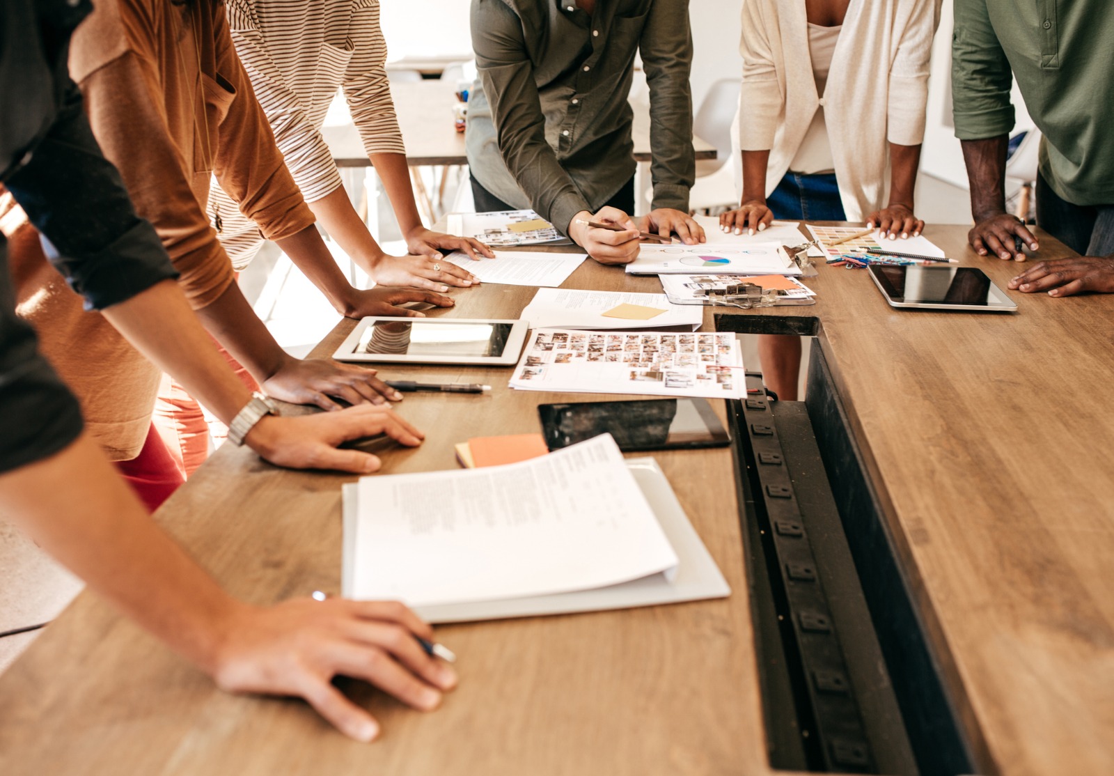Gens d’affaires debout autour de la table dans la salle de réunion.