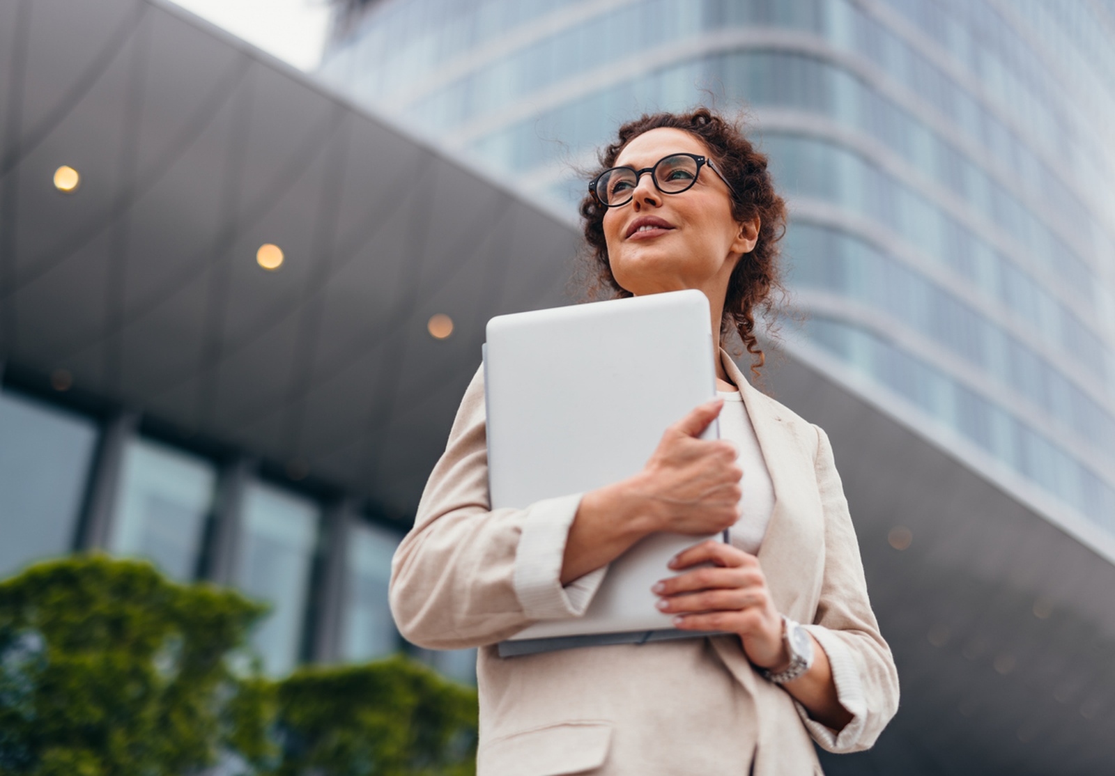 Professionnelle confiante évoluant dans un environnement urbain moderne, prête à relever les défis du monde des affaires.
